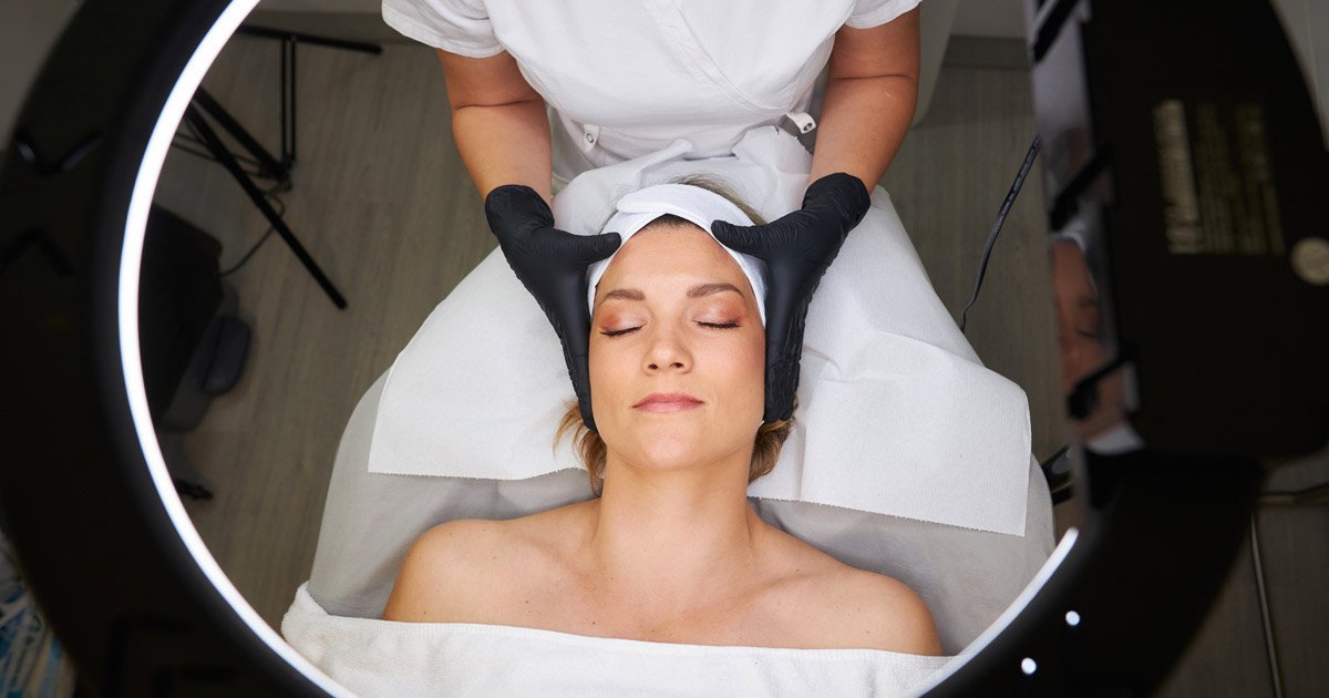 Close-up of lash treatment with eye pads applied, using hygienic disposable couch roll on salon bed
