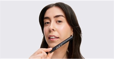 A woman holding the UKLASH Eyelash Growth Serum